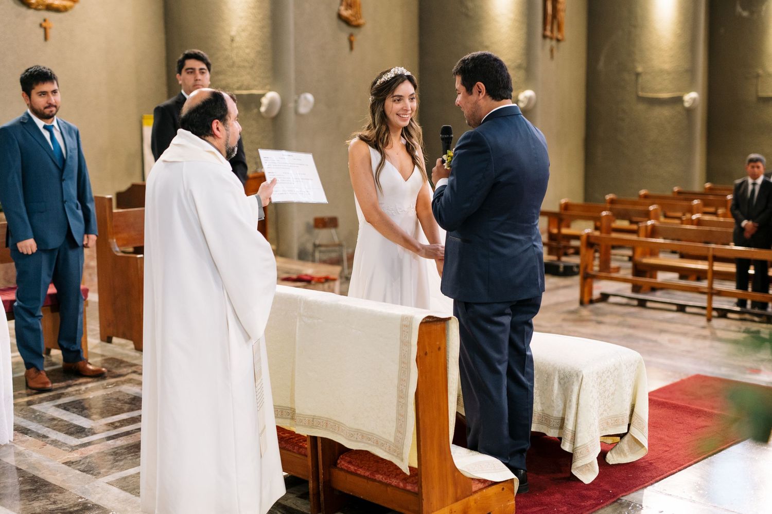 A couple stands at the altar during their traditional Catholic wedding ceremony.