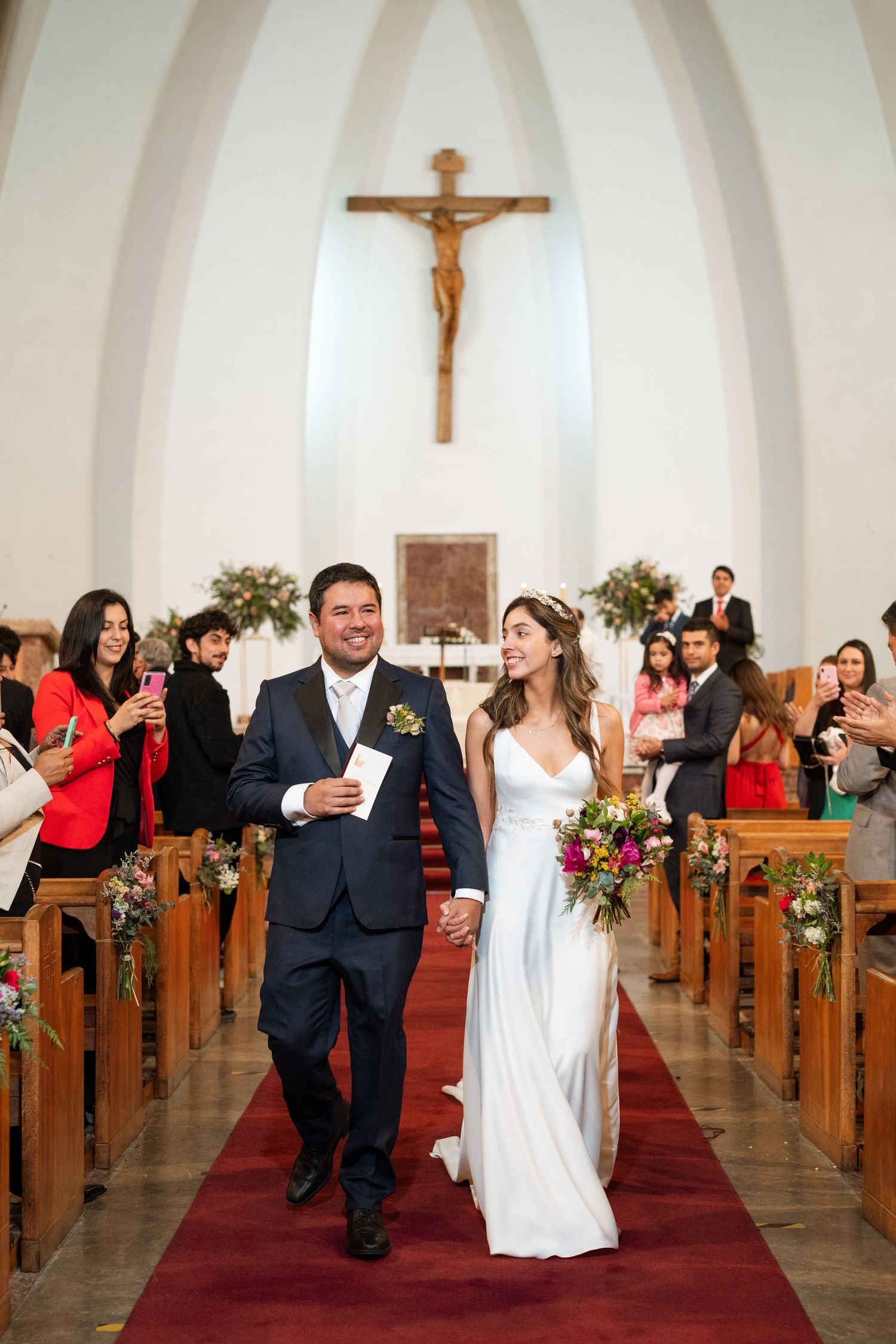 Traditional church ceremony with crucifix and arched architecture in warm lighting.