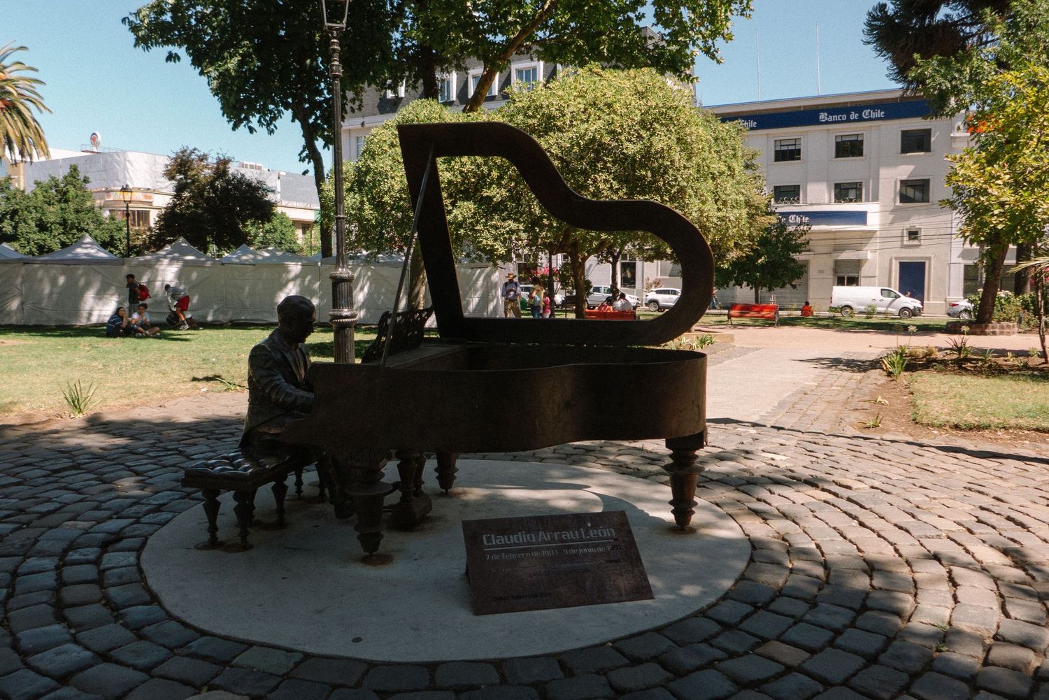 A decorative piano sculpture displayed in a circular stone plaza.