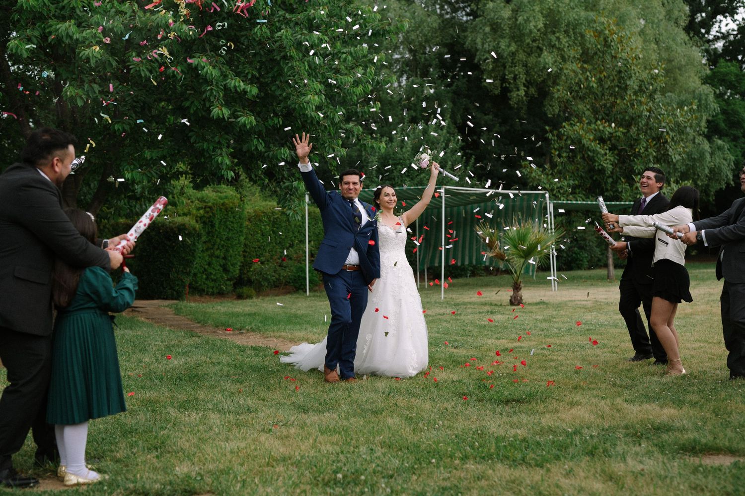 Wedding celebration in garden with guests celebrating the newlyweds.