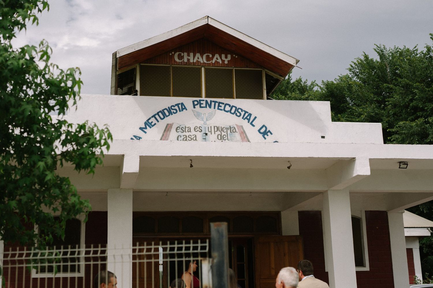 White church building facade with 'Chacaw' signage on a cloudy day.