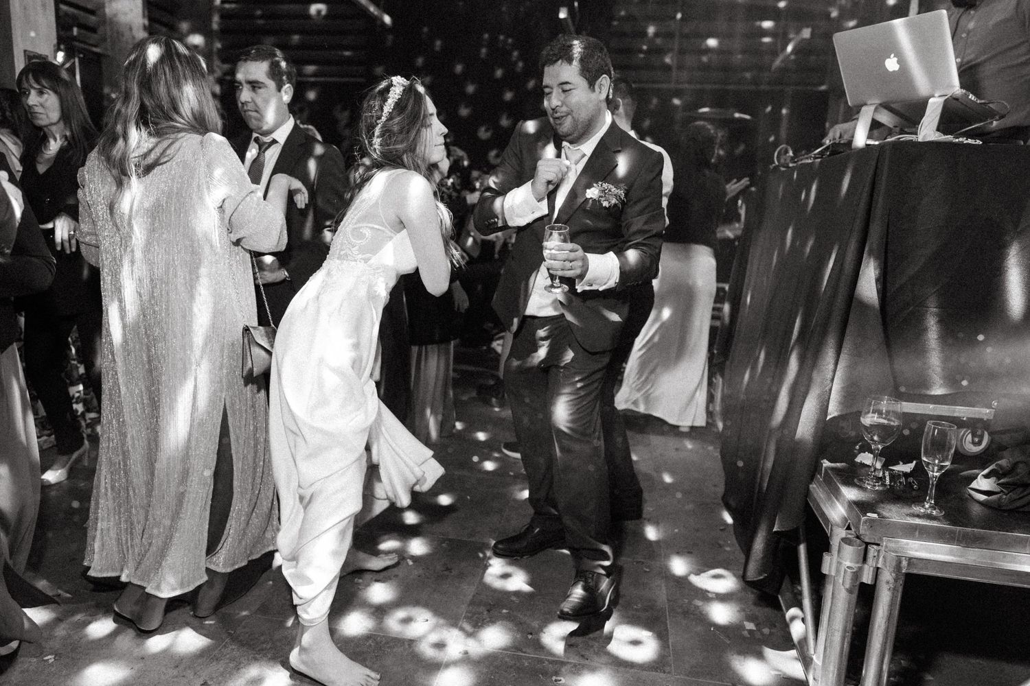 Black and white shot of wedding reception dancing under spotlights.