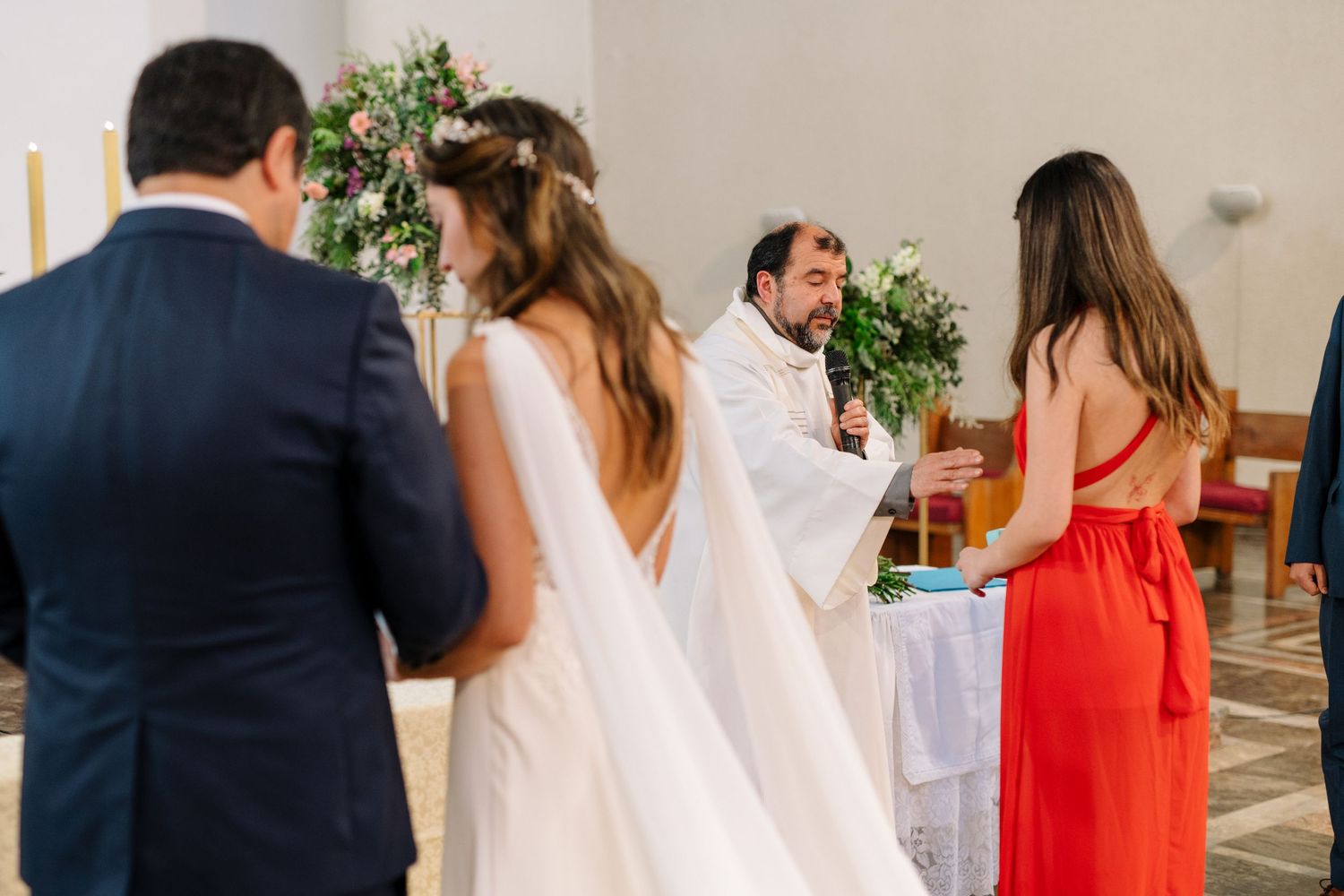 A priest performs a ceremonial blessing during a Catholic wedding service.