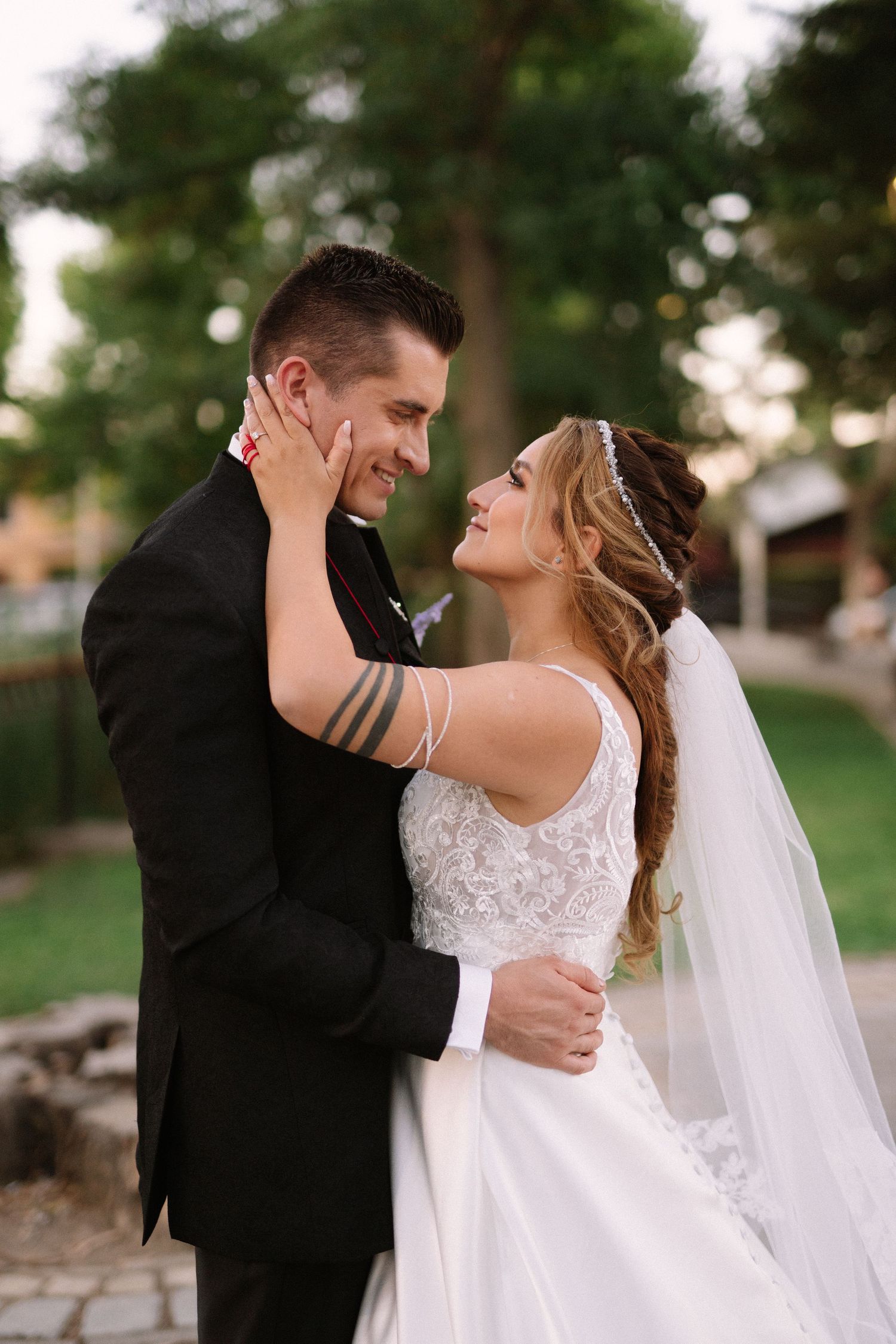 A loving portrait of newlyweds sharing an intimate moment in a park setting.