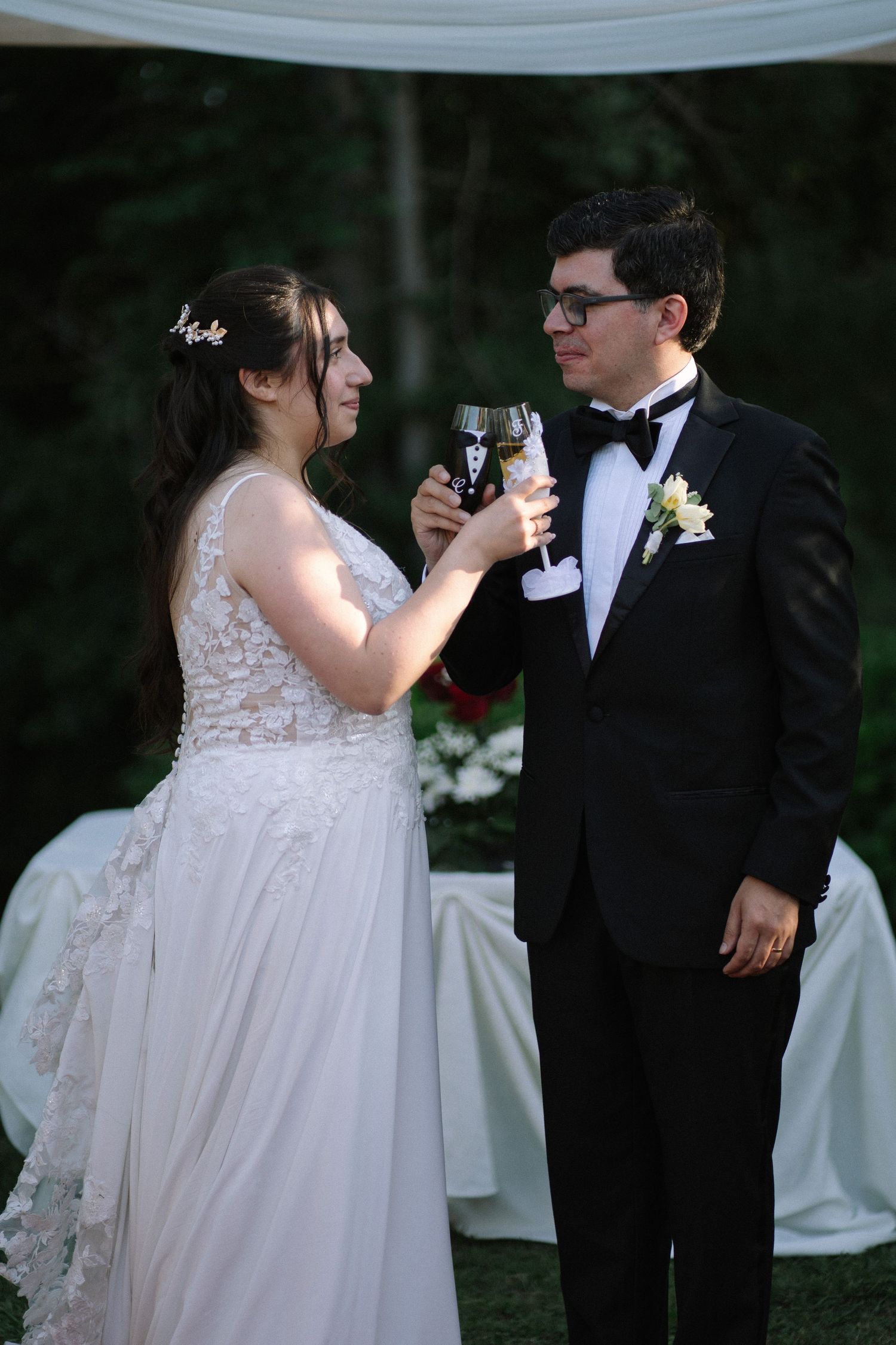 Wedding toast moment at outdoor reception with formal attire.