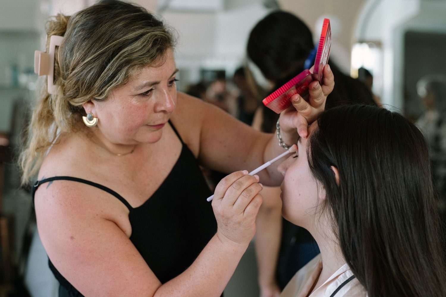 Makeup artist applying cosmetics with professional brushes and tools.