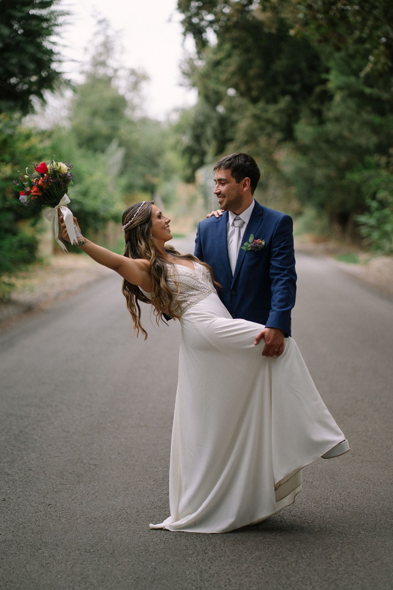 A romantic wedding photoshoot sequence on a tree-lined path with dramatic dip poses.