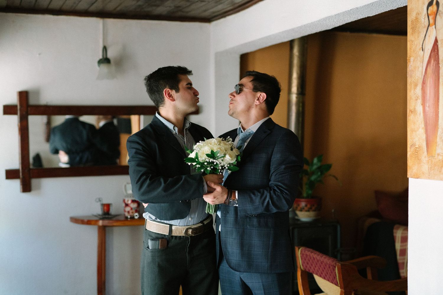 Two people in suits sharing intimate moment with flowers.
