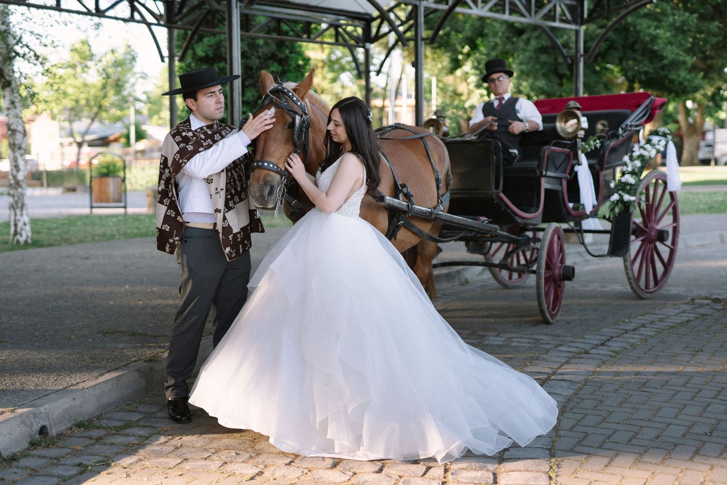 A couple shares a romantic moment next to a vintage horse-drawn carriage during their wedding celebration.