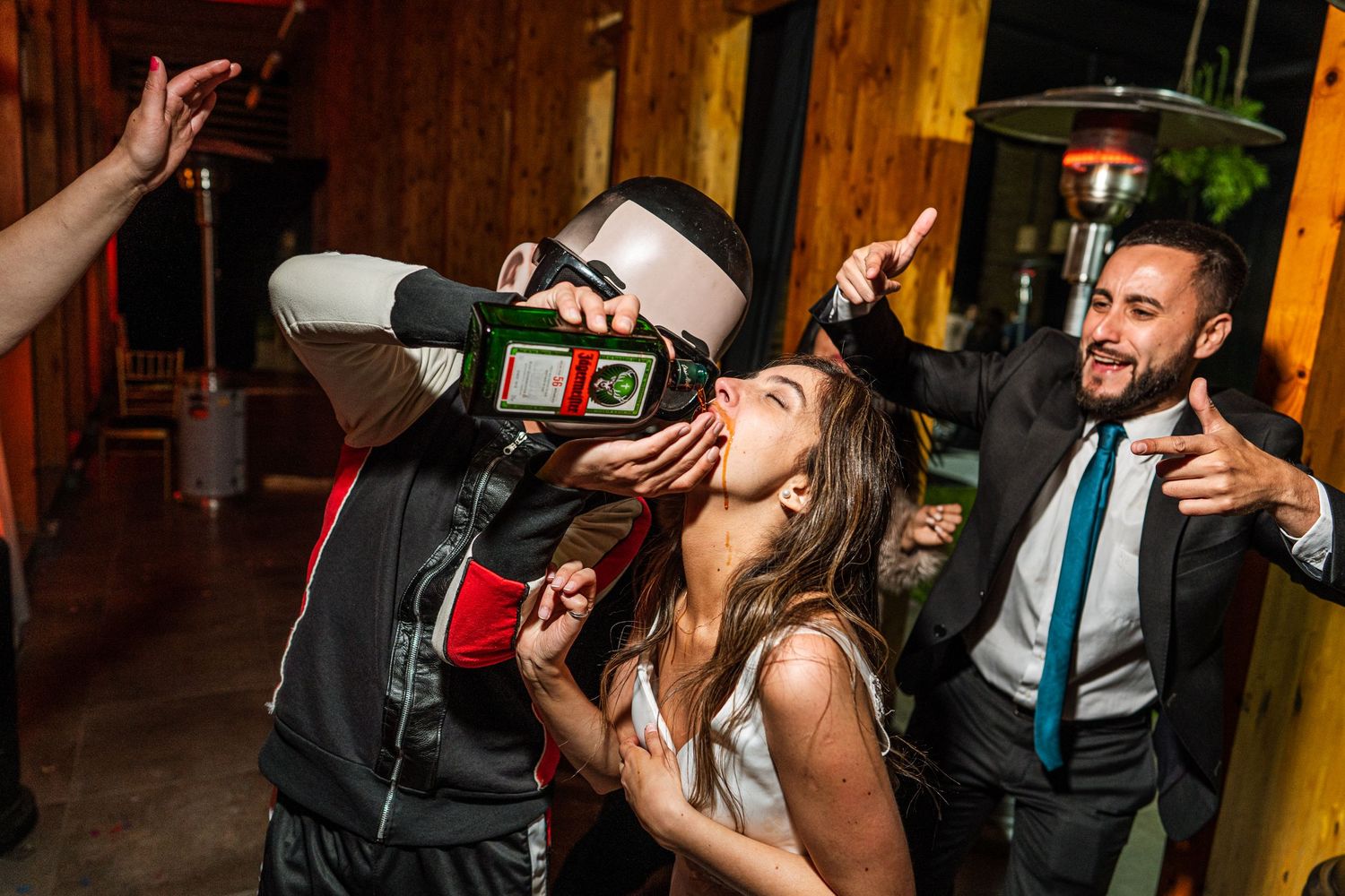 Enthusiastic celebration with drinks being poured at a lively indoor venue.