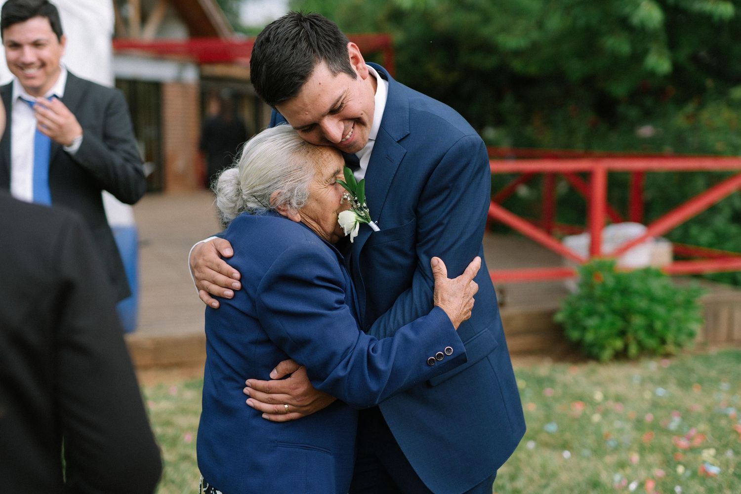 Emotional embrace during wedding celebration outdoors.