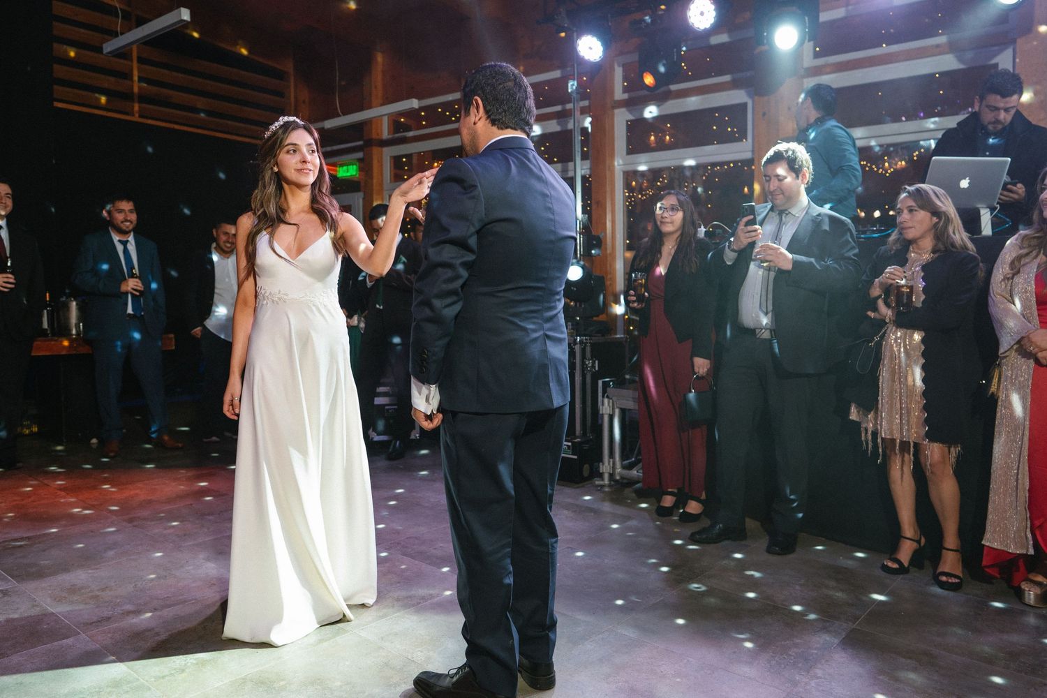 Wedding dance with confetti falling under stage lights at reception venue.
