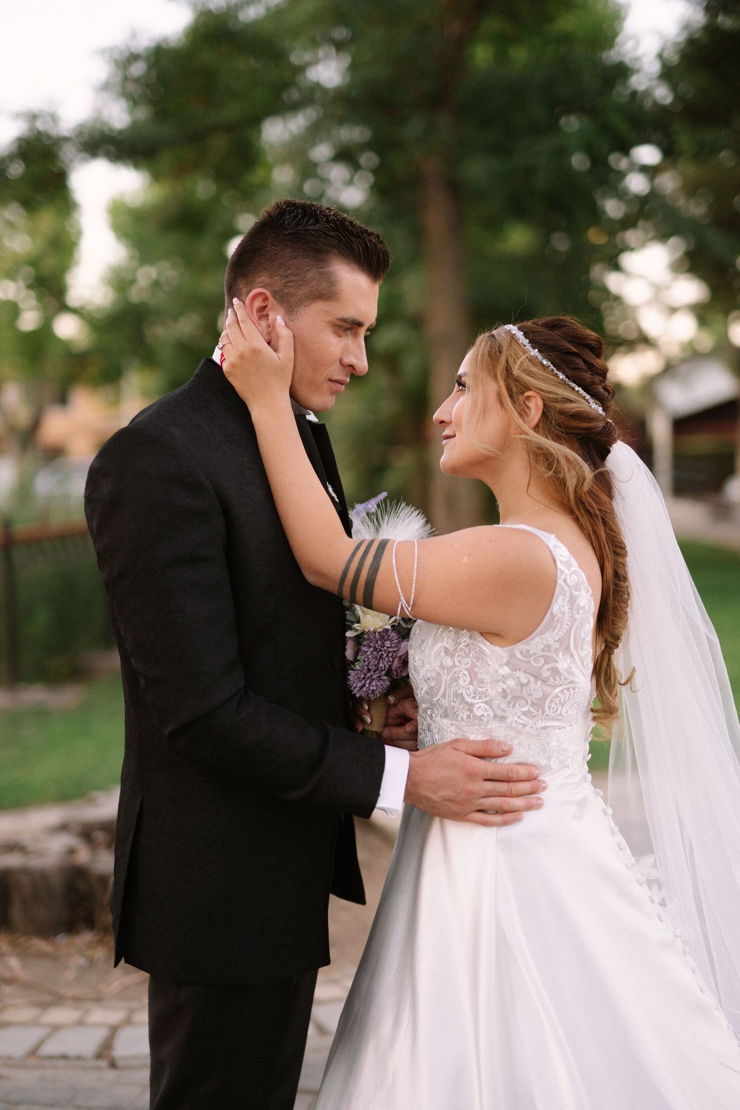 An intimate moment between newlyweds in formal attire during their outdoor wedding photoshoot.
