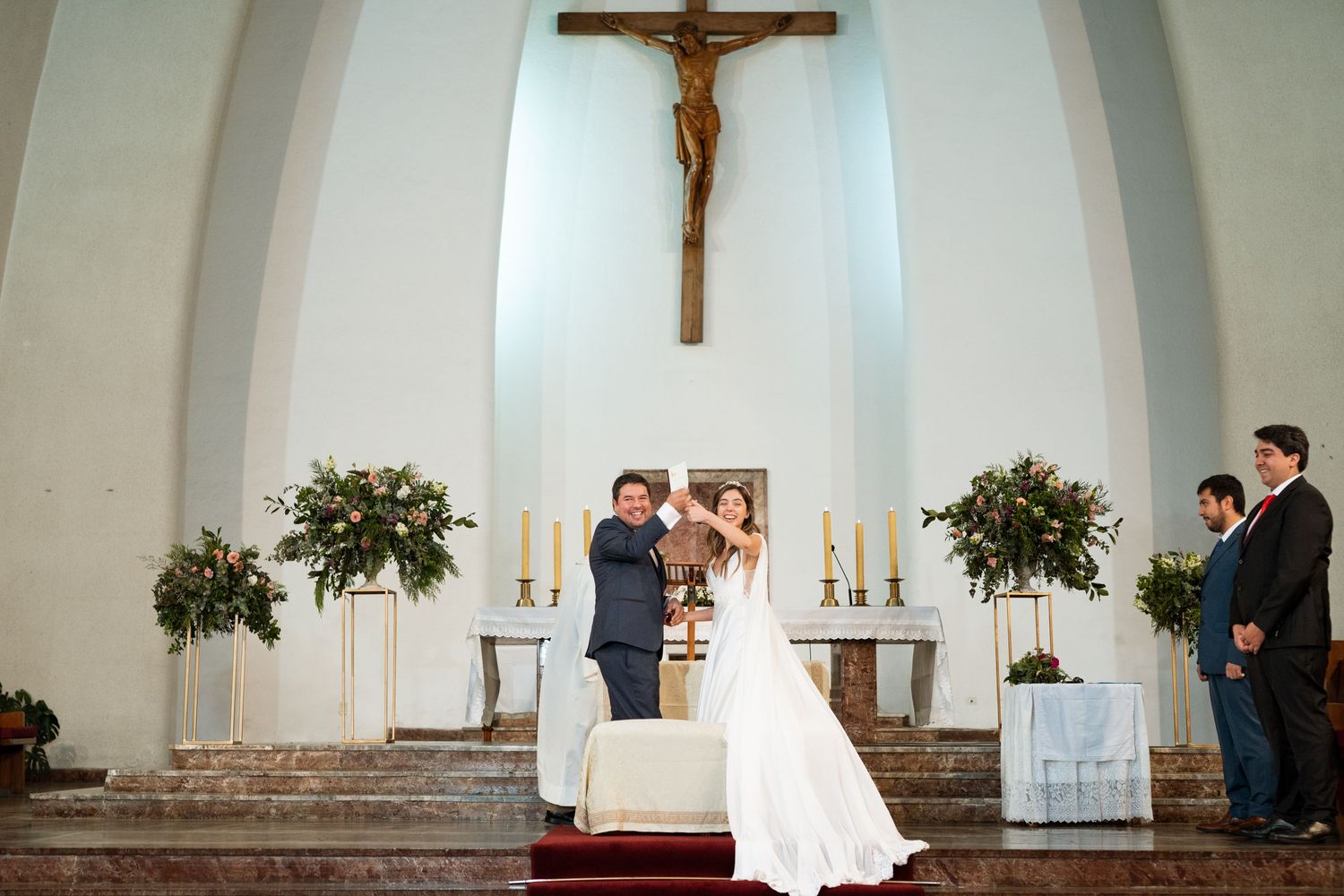 Religious wedding ceremony in white church with traditional altar setup and decorations.