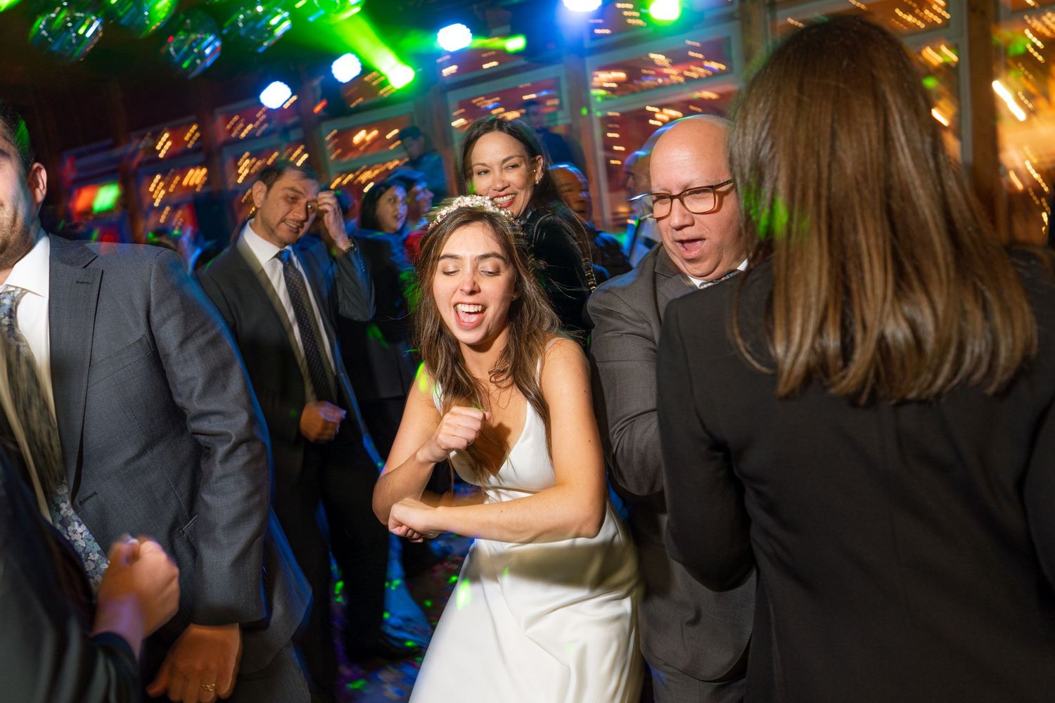Wedding reception dance party with disco lights and guests enjoying themselves.