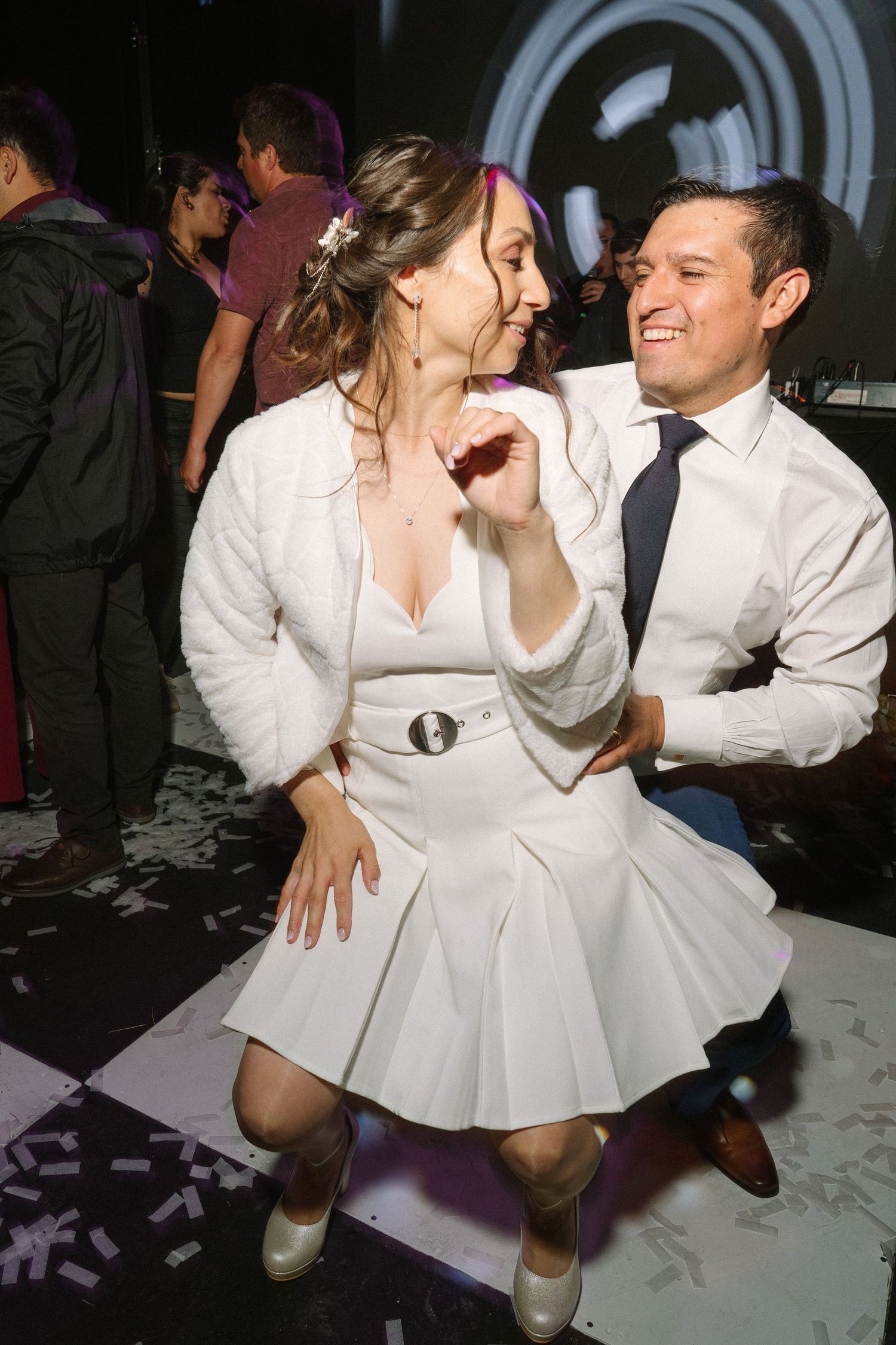 Joyful dancing moment captured on a nightclub-style wedding reception dance floor.