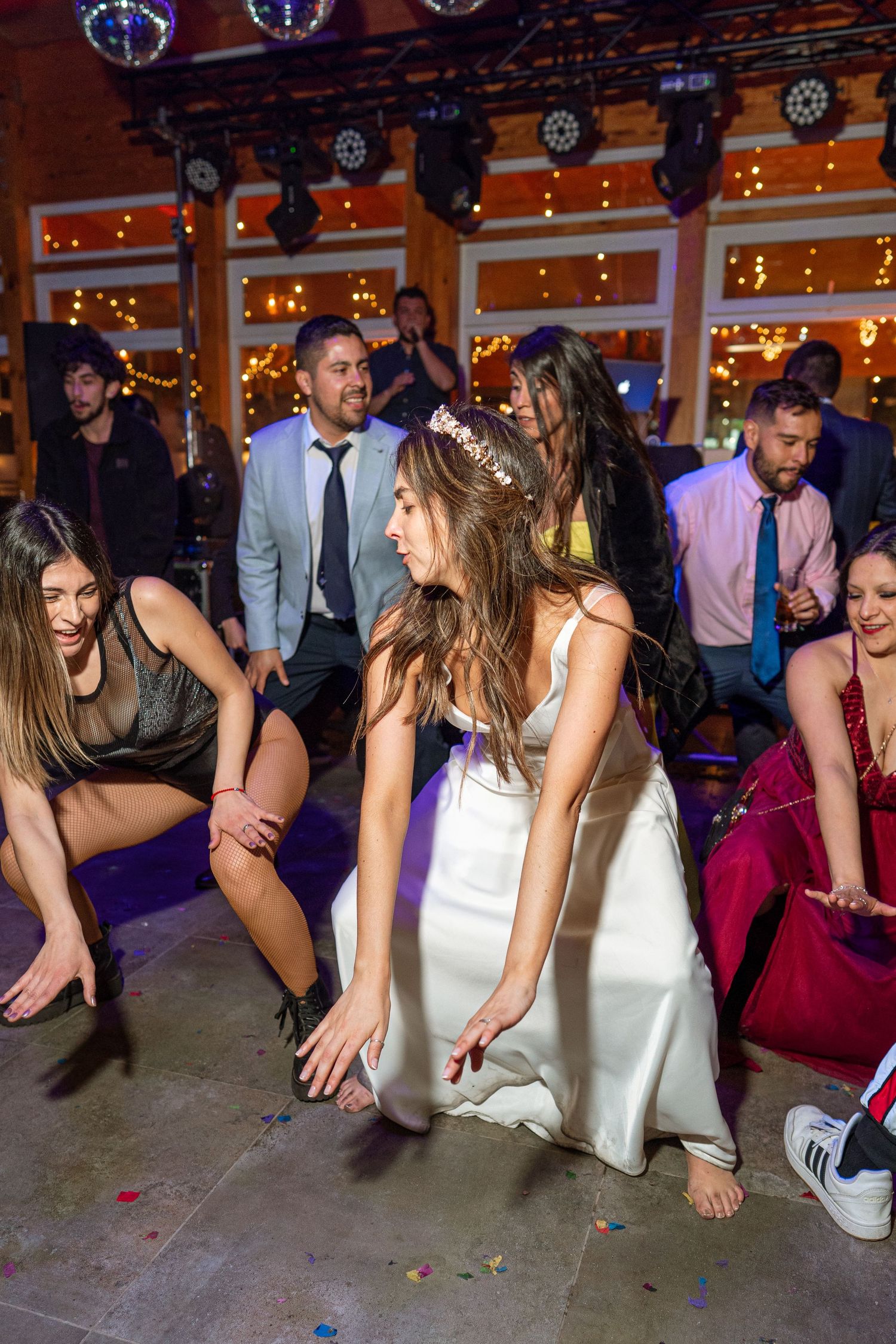 Partygoers enjoying dance moves on an illuminated dance floor during a celebration.