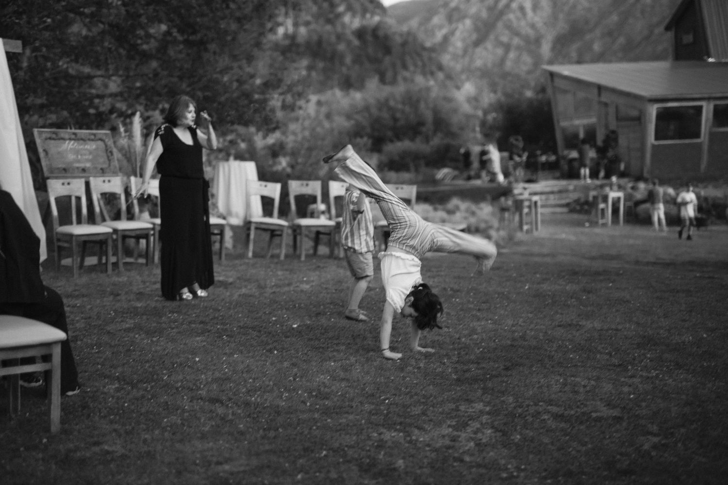 Black and white image of outdoor wedding celebration on a grassy lawn.