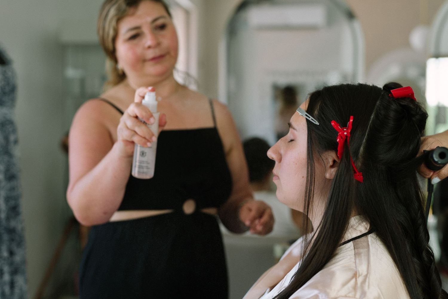 Makeup preparation scene with setting spray and hair accessories.