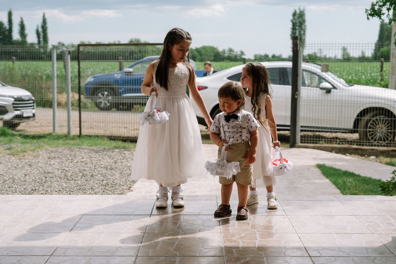 Wedding party members walking along pathway in formal attire.