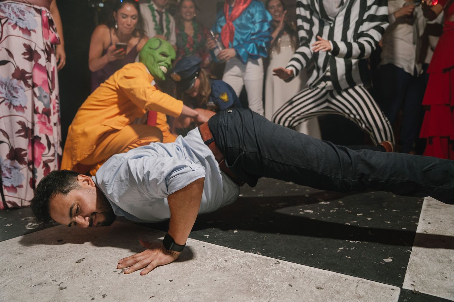 Several people lying down on a dark surface in a row wearing casual clothing.