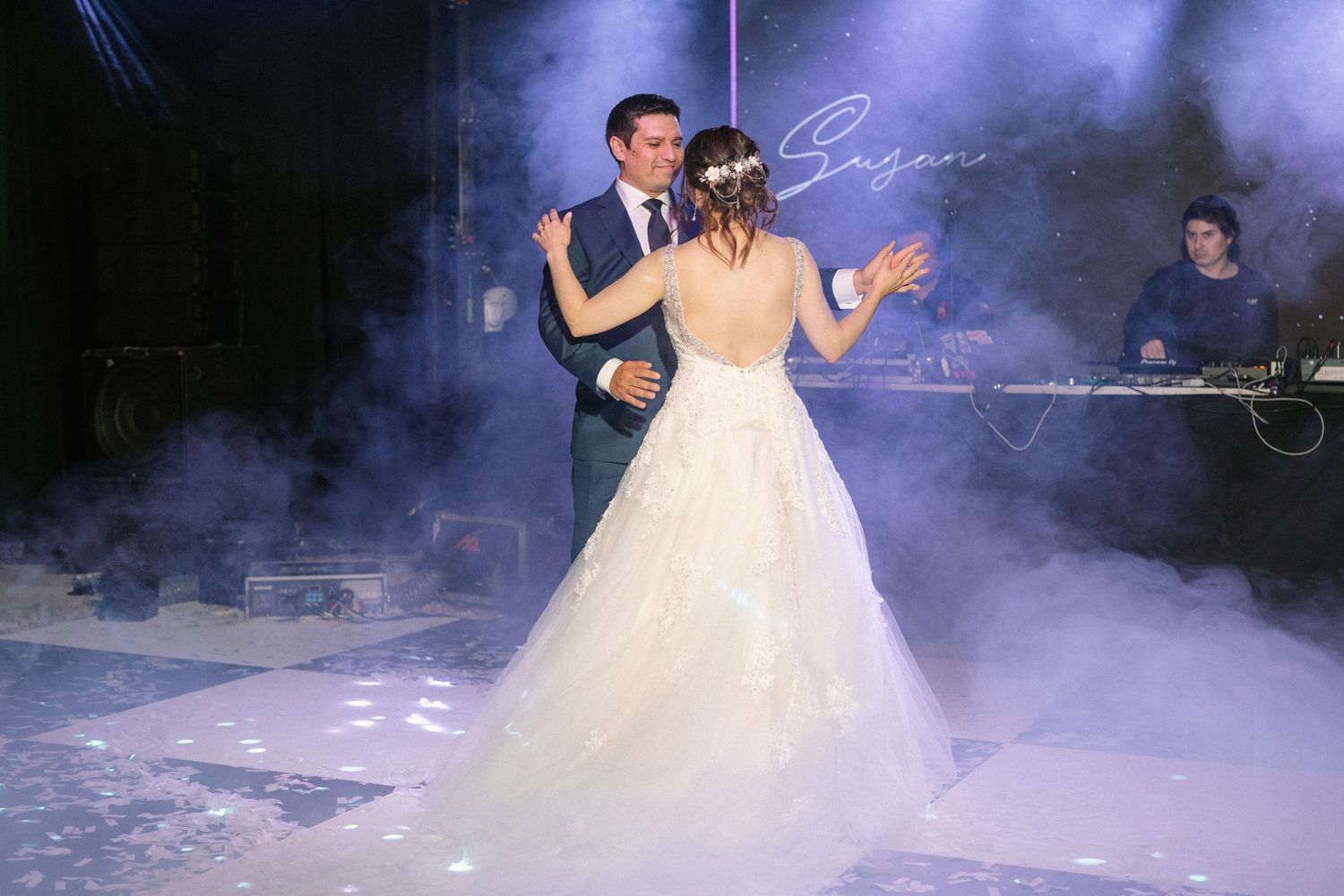 A romantic first dance at a wedding reception with dramatic purple smoke effects and lighting.