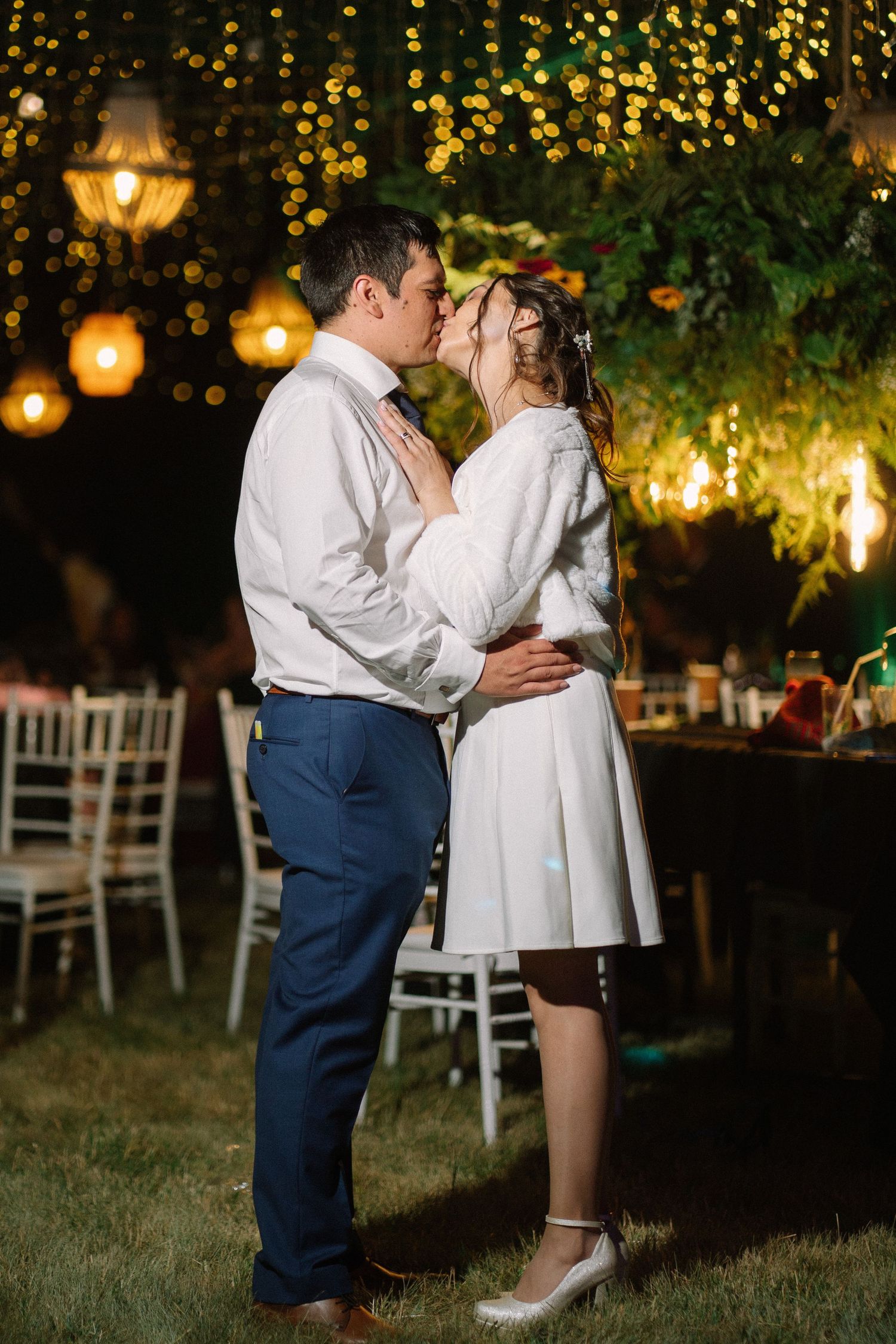 A romantic evening moment under twinkling lights in a garden setting.