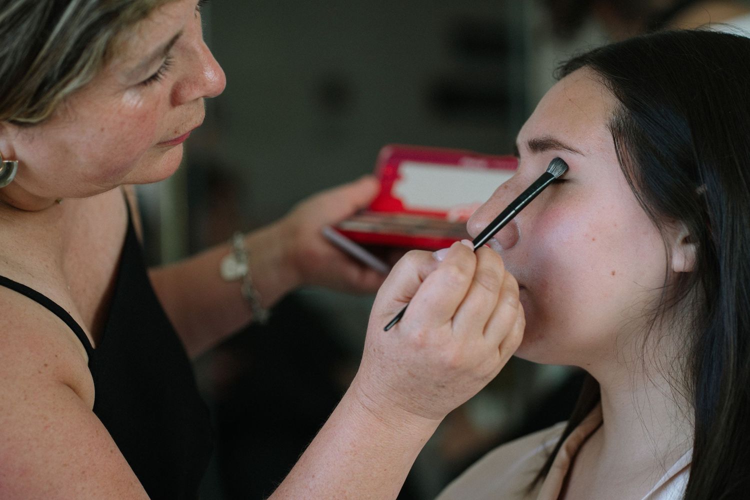 Professional makeup application showing brushwork around the eye area.