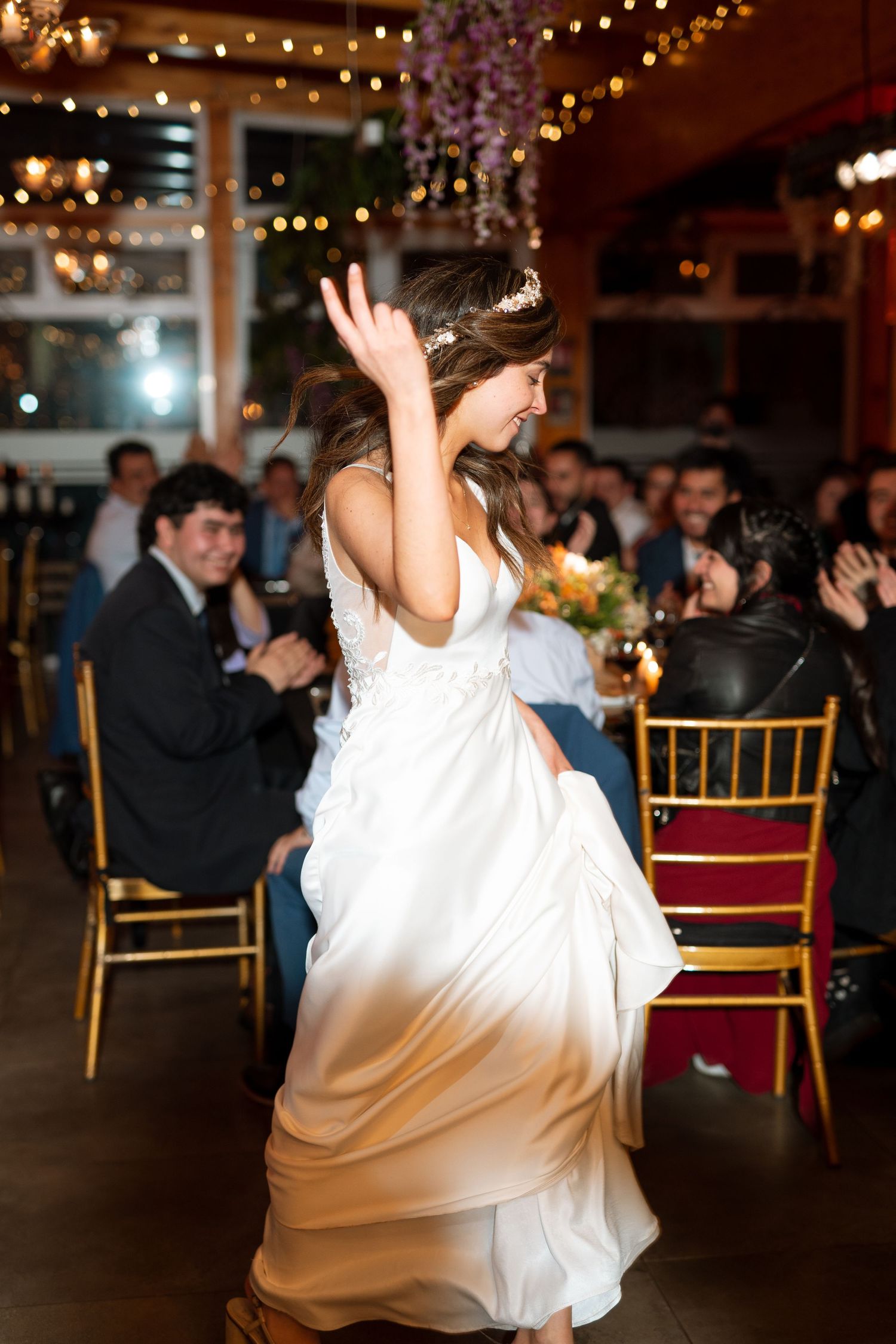 Dancing at wedding reception with elegant decor and string lights overhead.