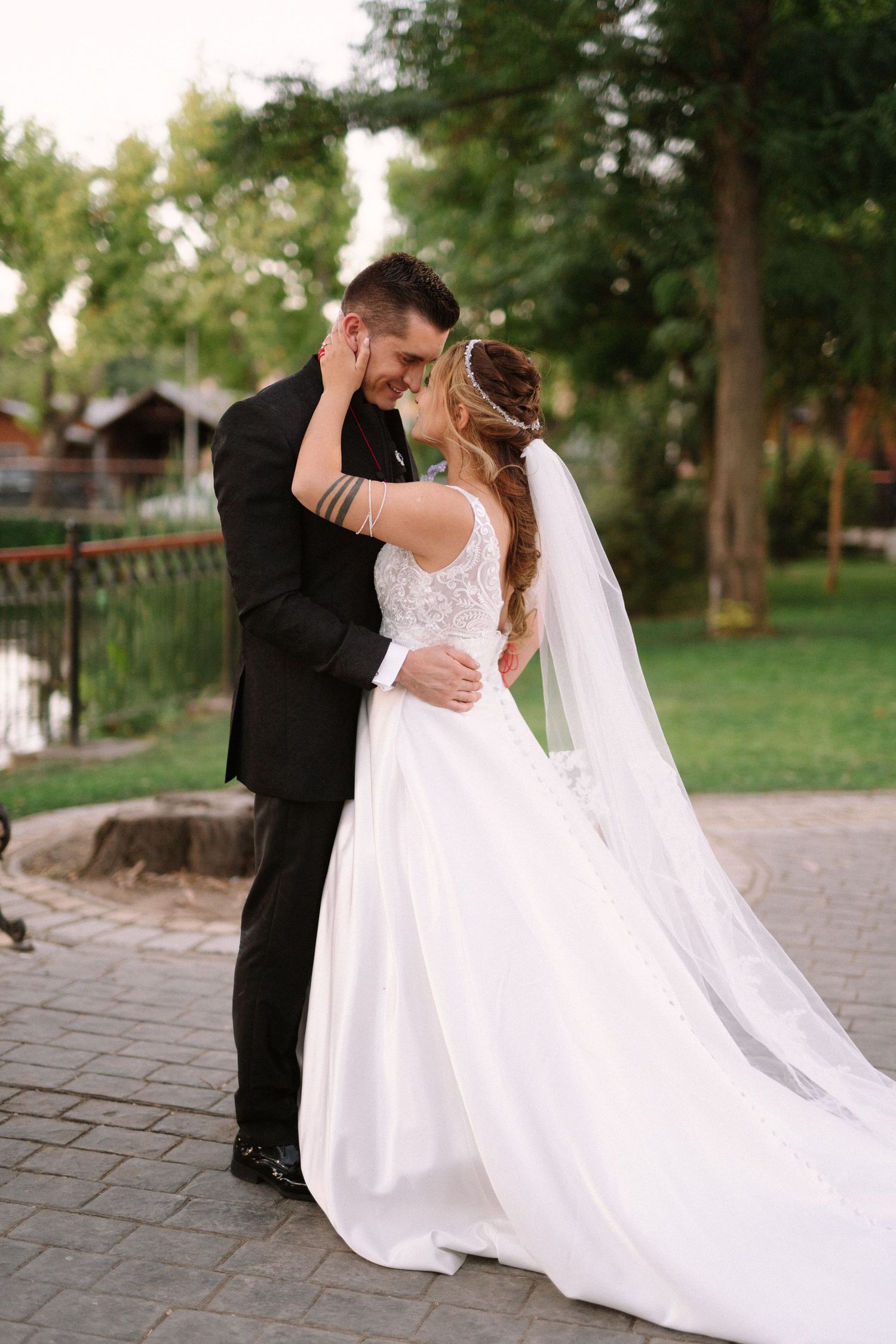 An intimate embrace between newlyweds on a brick pathway during golden hour.