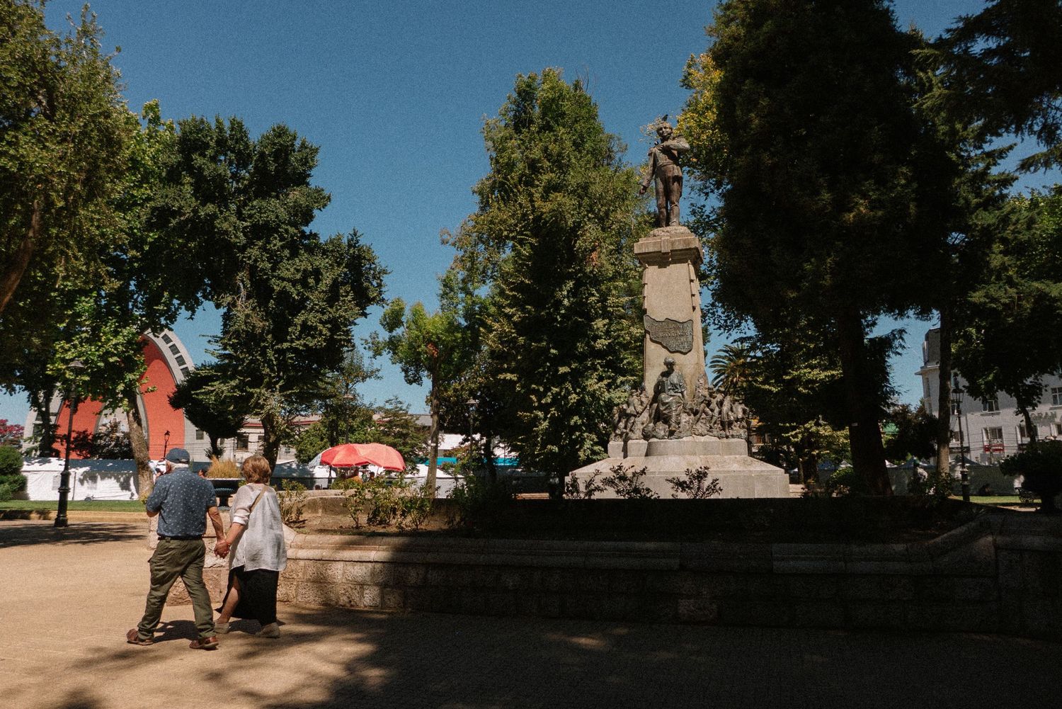 A historic monument surrounded by trees in a public park on a sunny day.