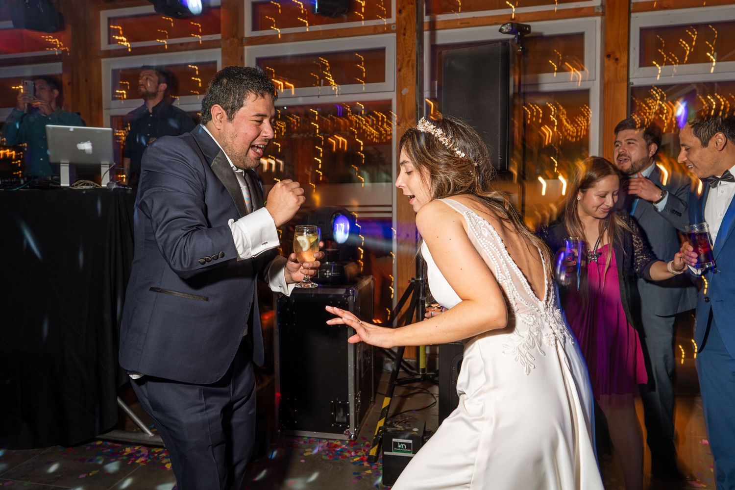 Dancing and celebrating at a wedding reception under venue lighting.