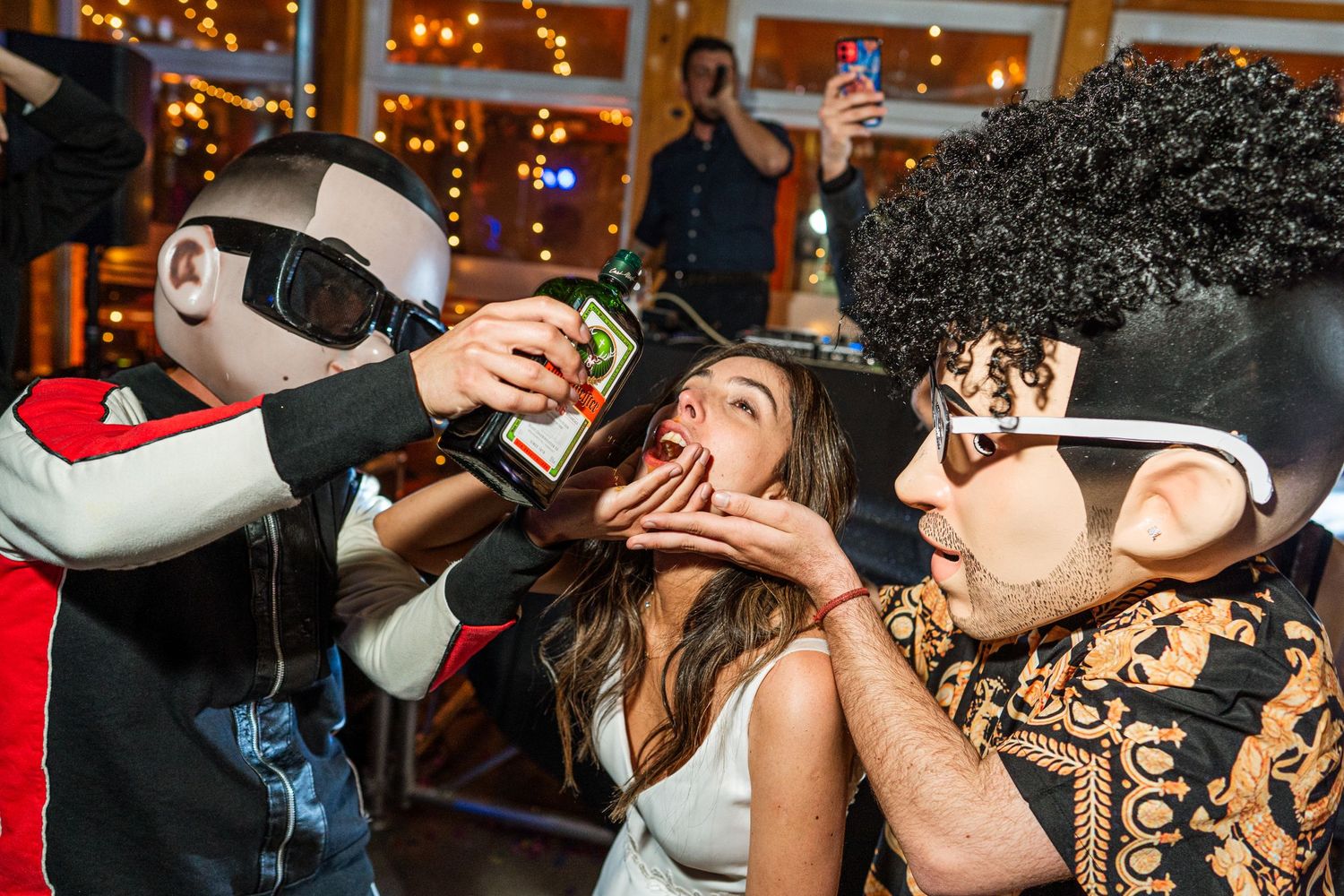 Partygoers engage in animated celebration with drinks under disco lights.