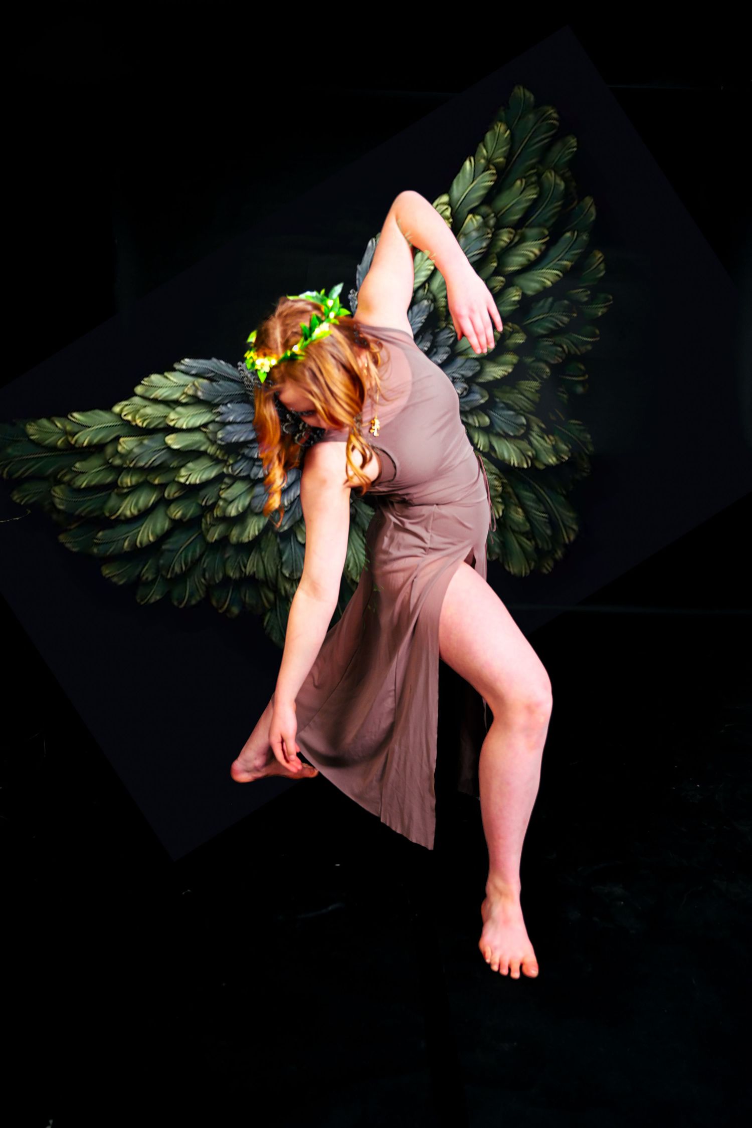 Artistic portrait with large decorative peacock wings against black background.