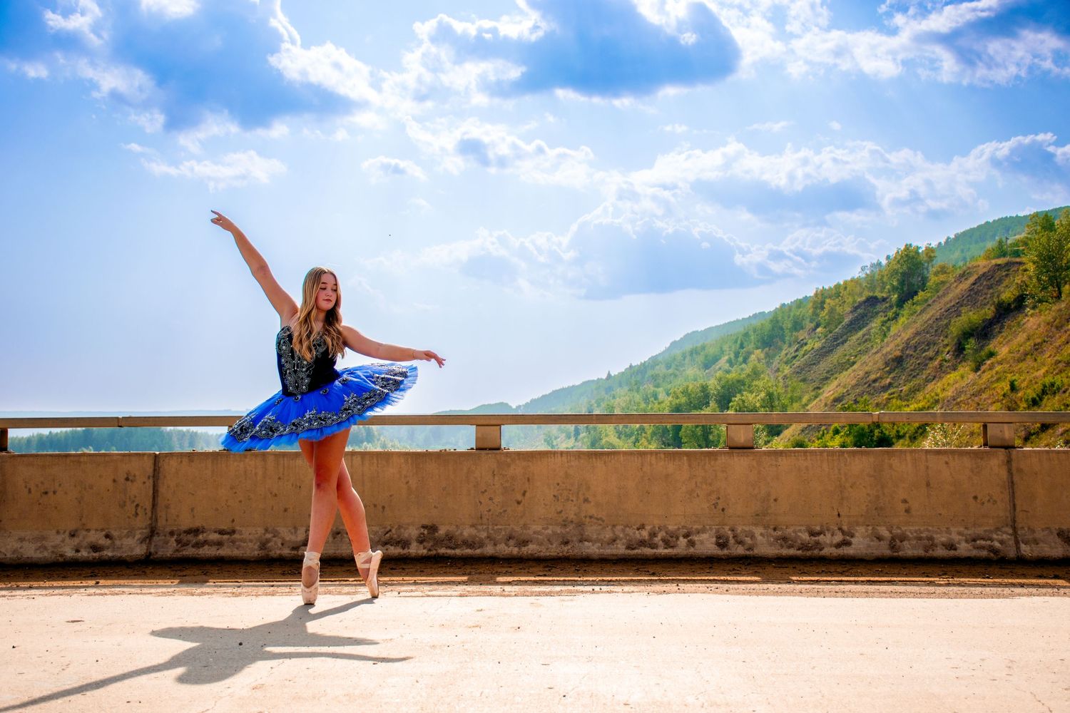 A ballerina, en pointe, posed on a bridge