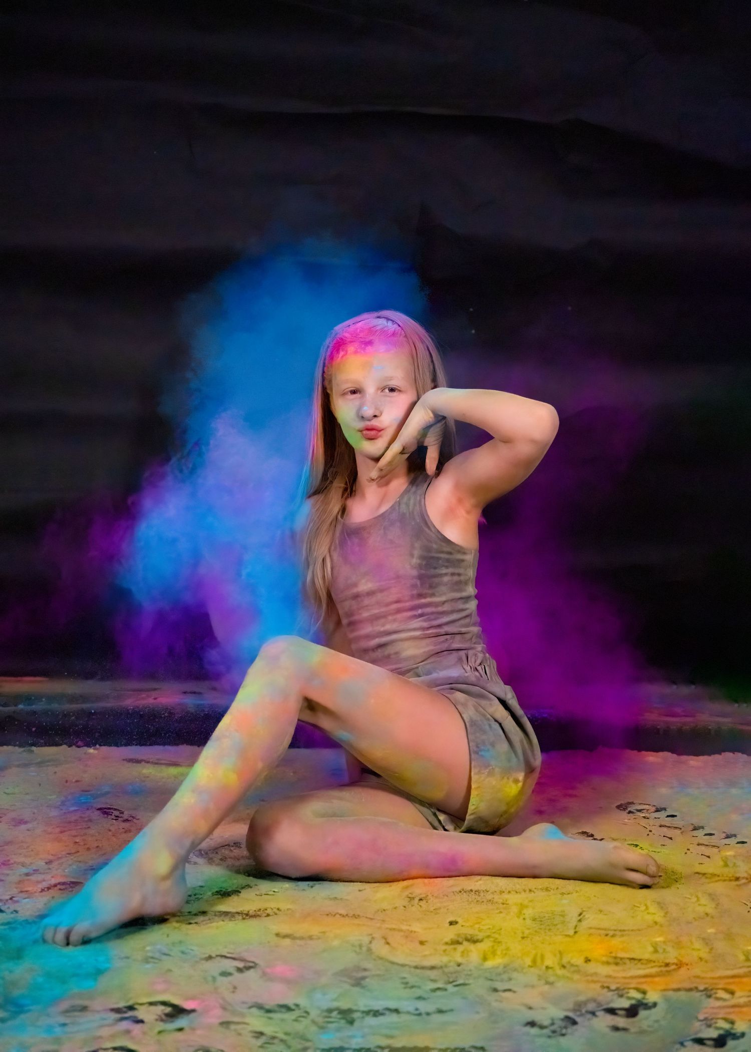 Dance portrait with colorful powder effects in blue and pink against dark background.