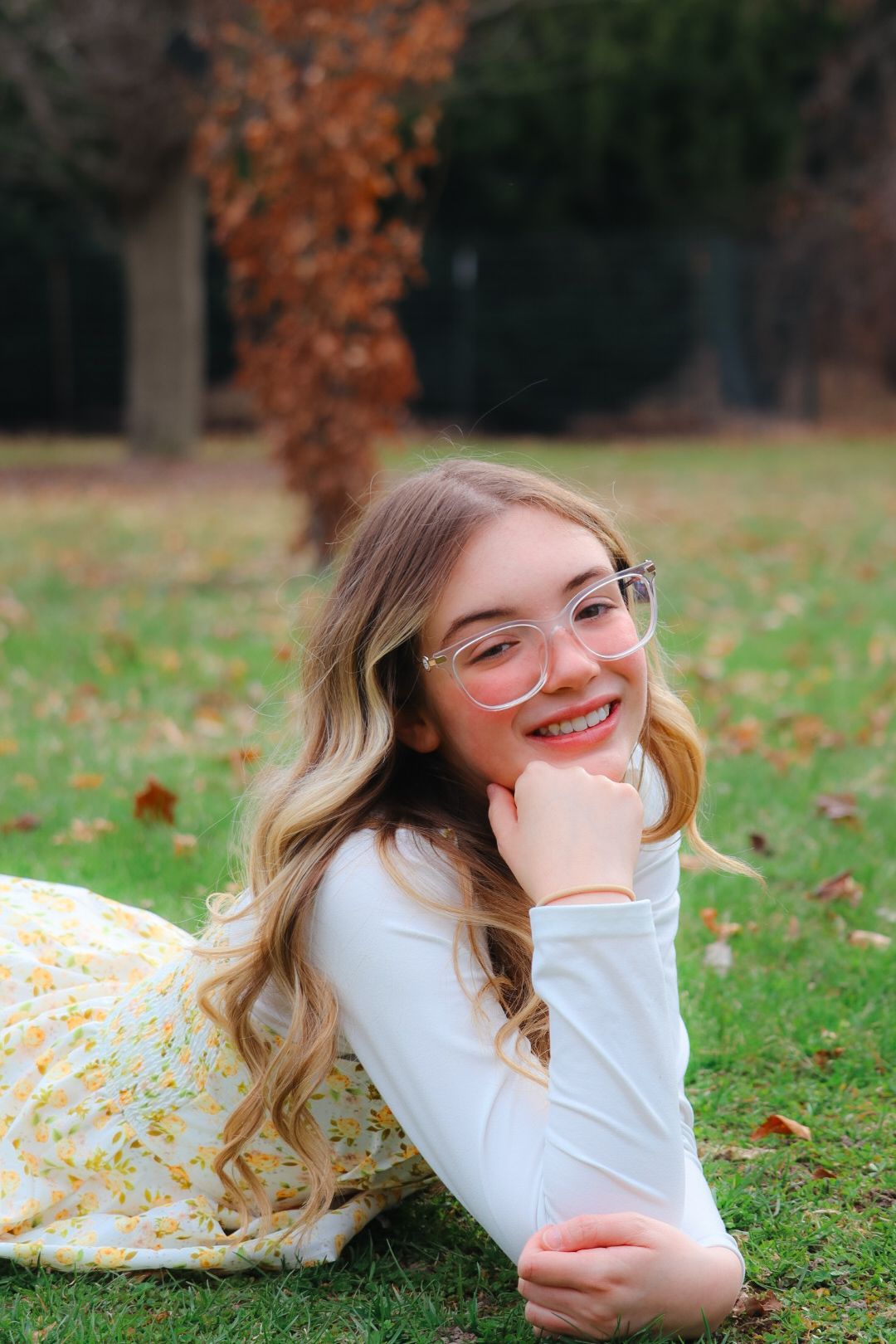 senior girl photoshoot, girl laying down with her head resting on her hands