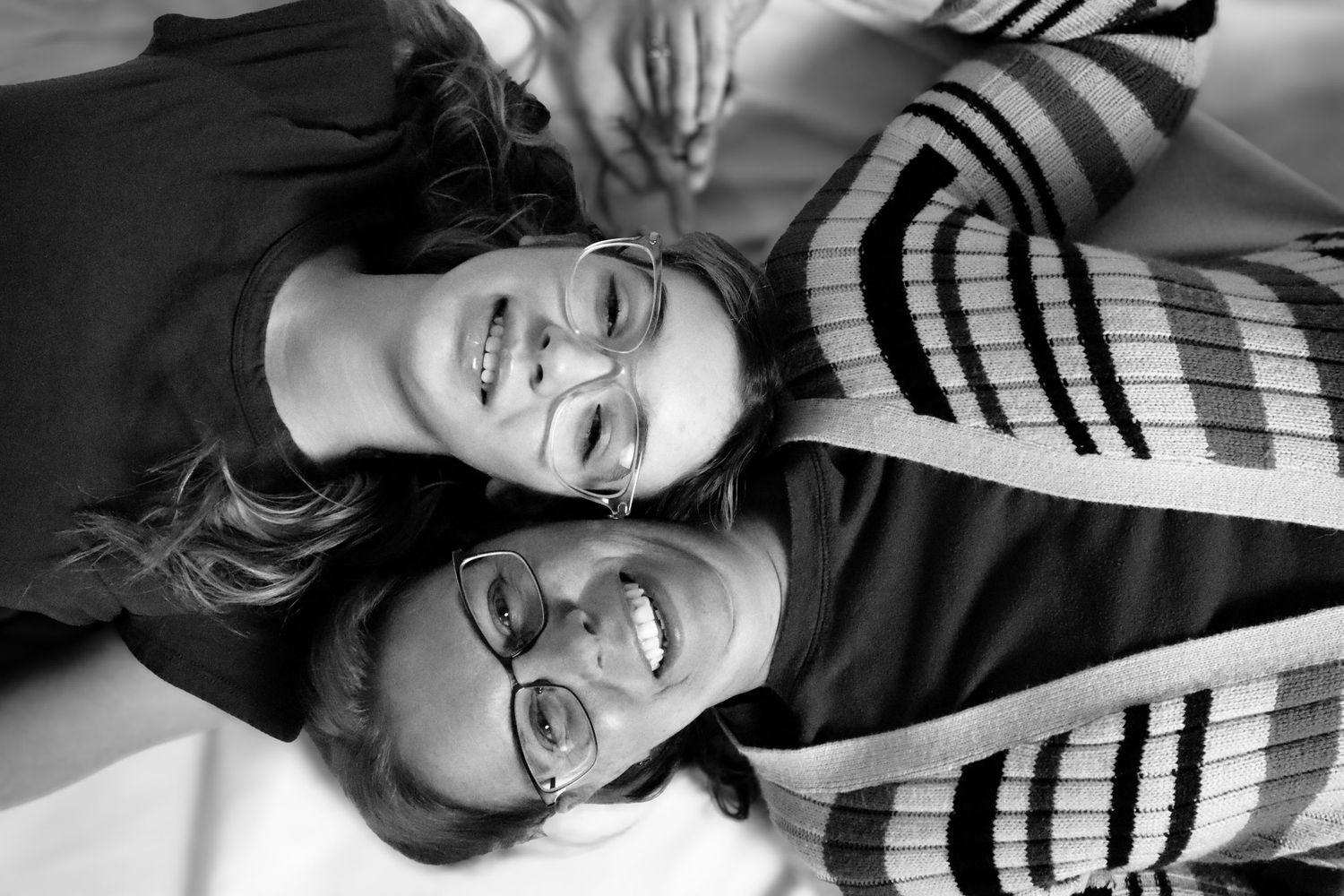 mother and daughter lying ont the ground, heads together, b&W, studio shoot
