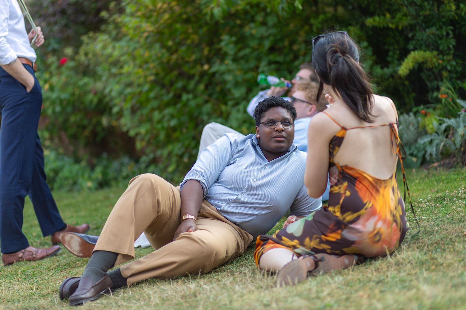Wedding guests relaxing on the grass after a wedding
