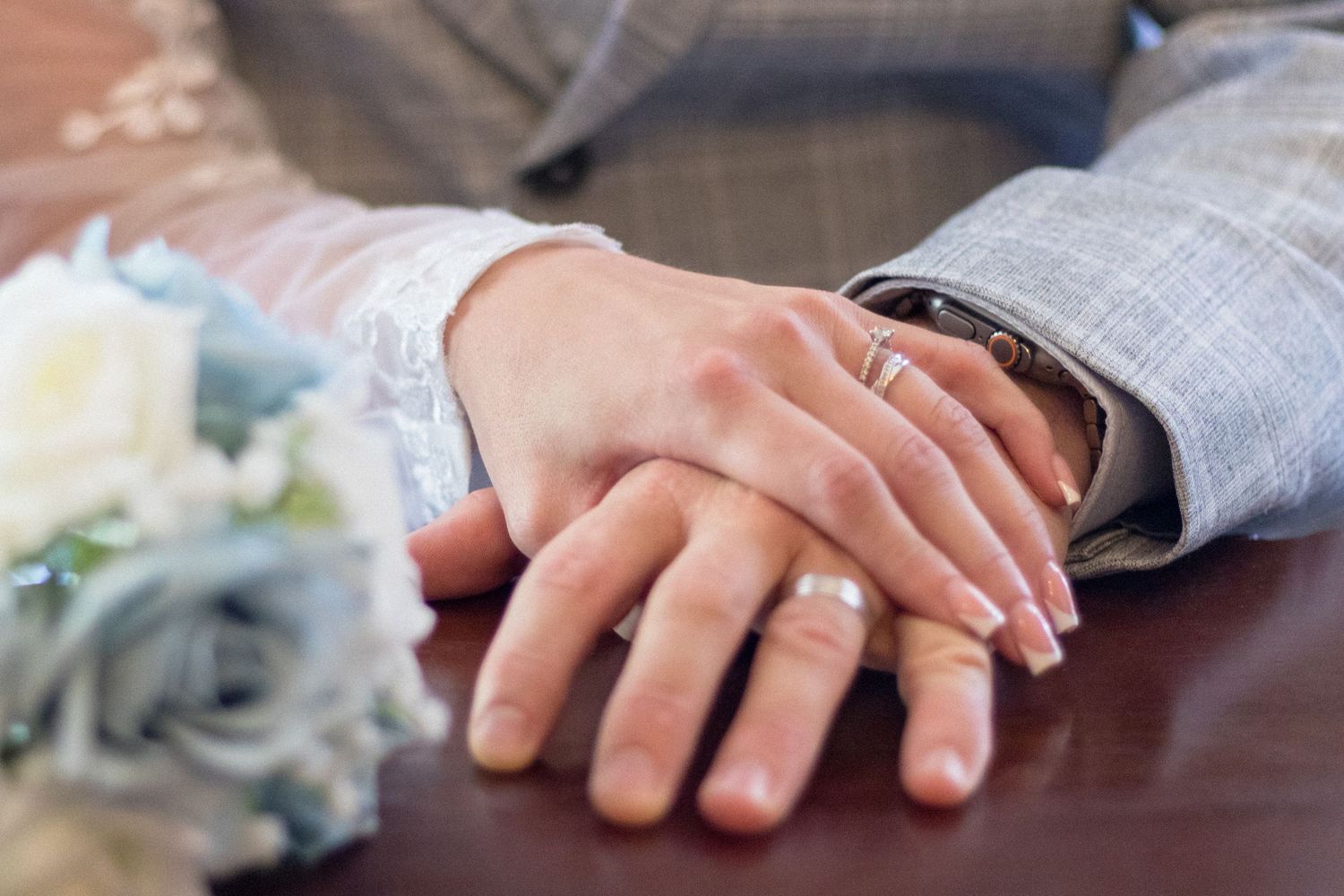 Bride and Groom holding hands showing off their rings