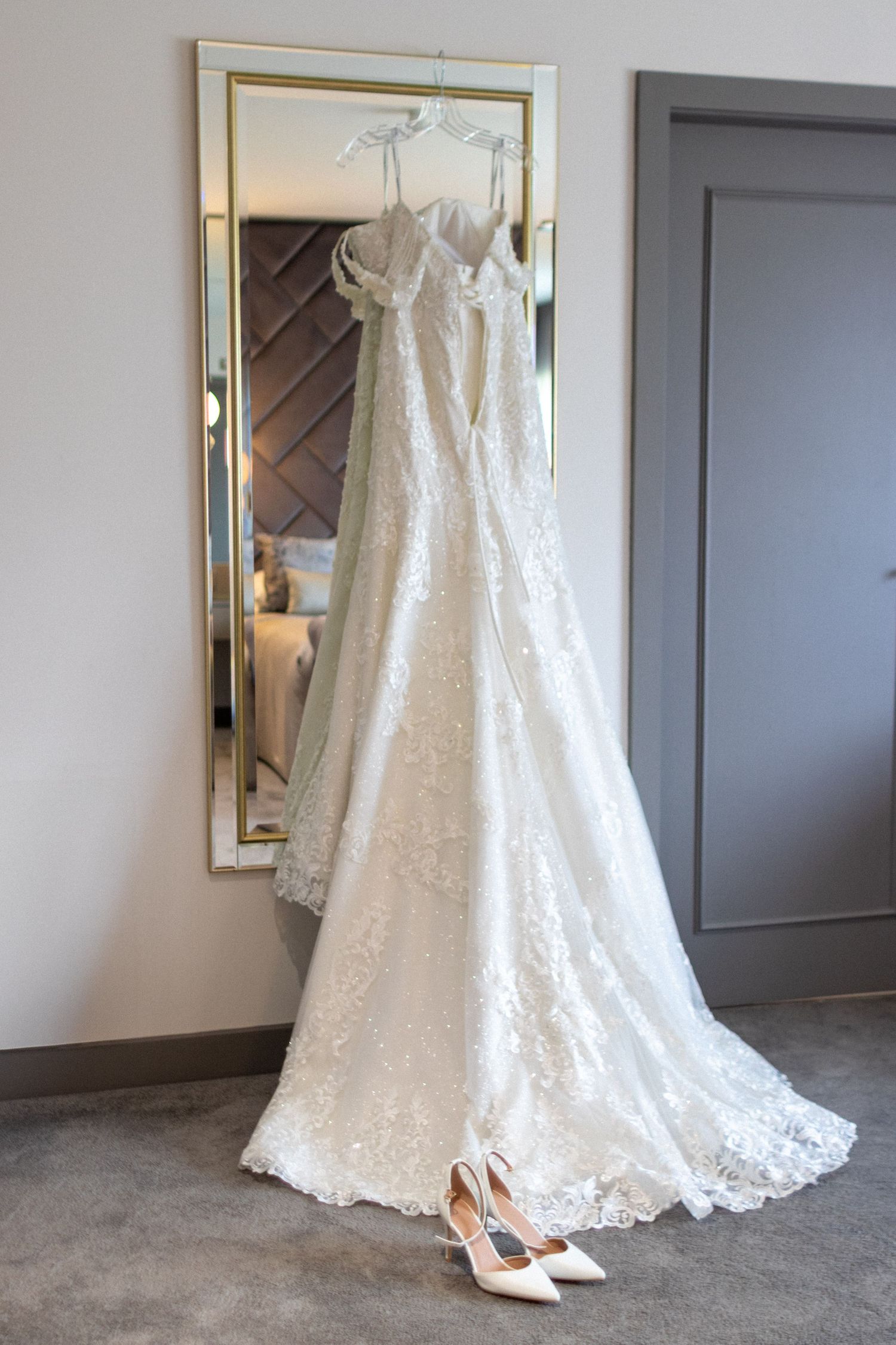 Wedding dress and shoes hung on a mirror