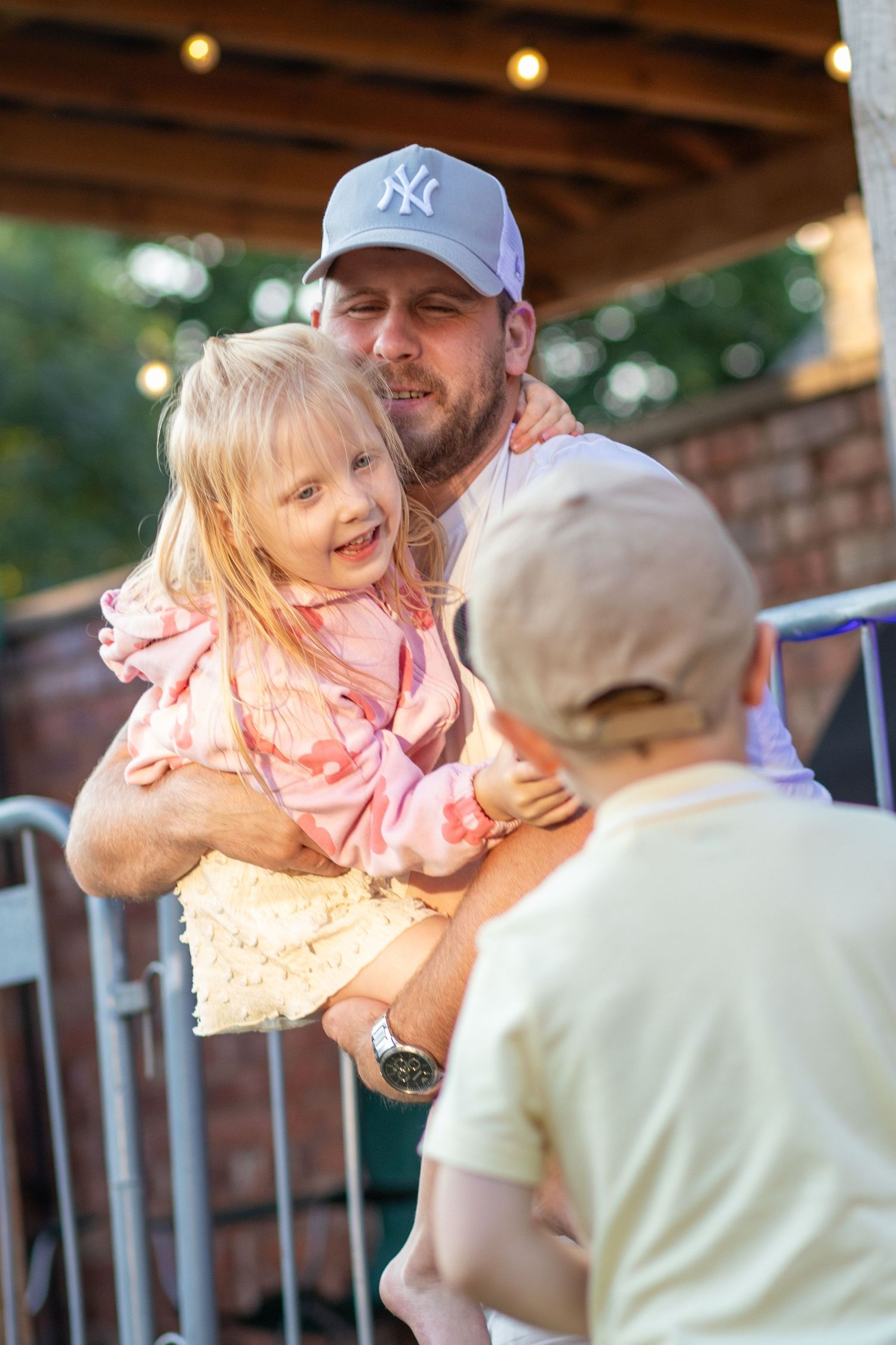 Candid photo of a Man holding his children, natural lighting