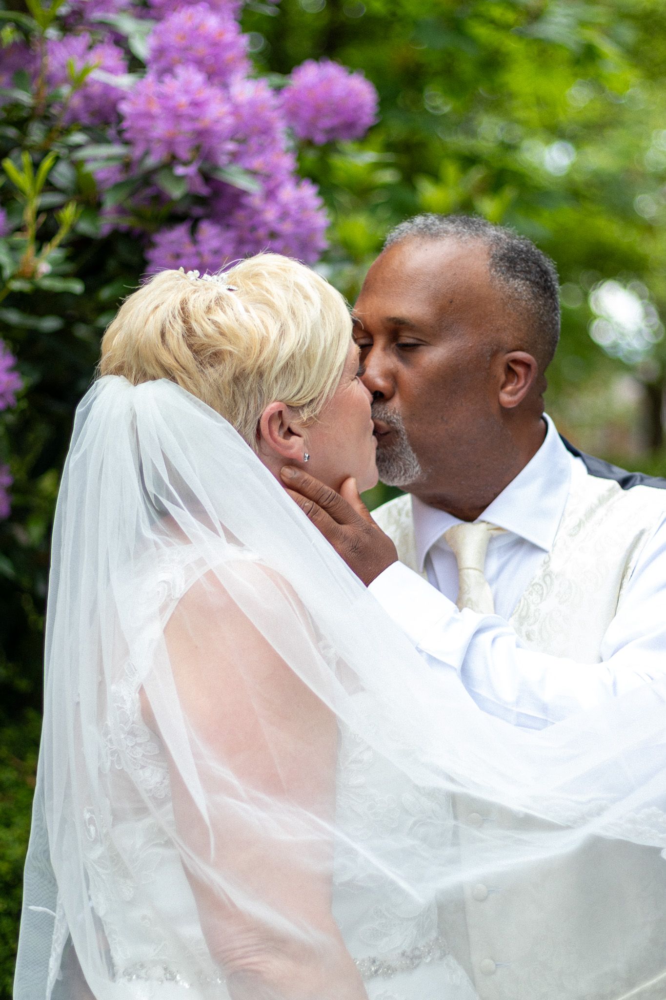 Bridge and Groom kiss outdoors after their wedding