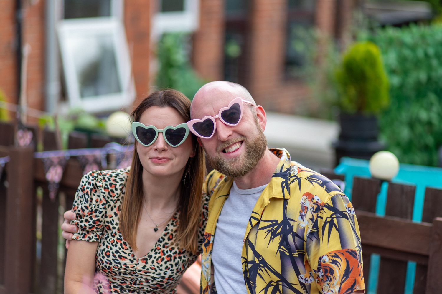 A couple in silly glasses outdoors posing for a photo