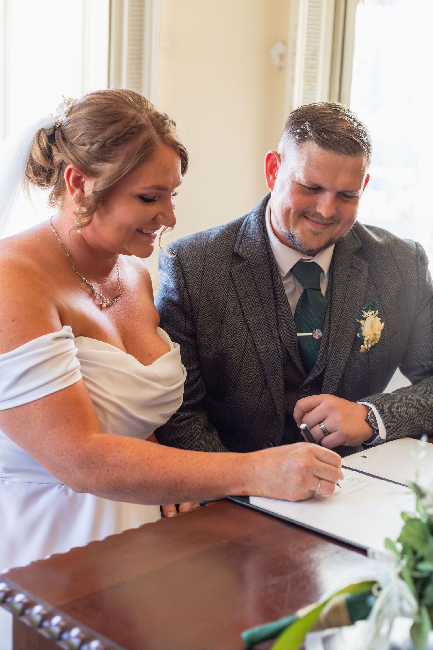 Bride and groom signing the wedding register at Clifton Park Museum.