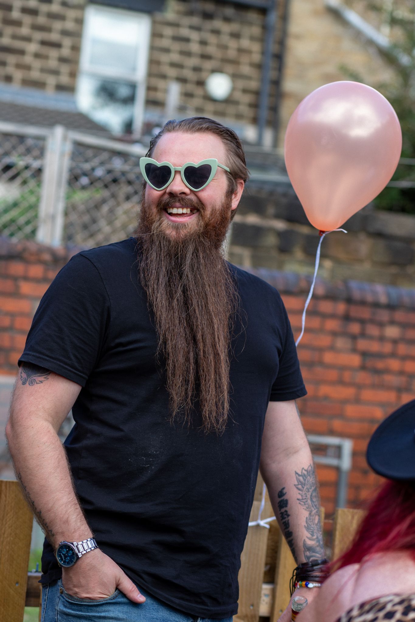 Man outdoors wearing silly glasses with a balloon