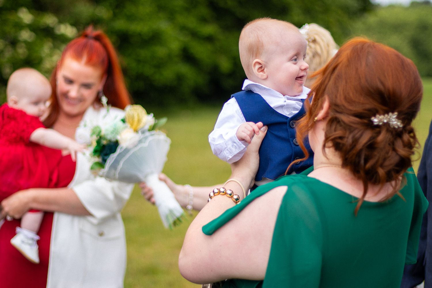 Family and Guests holding their children after a wedding