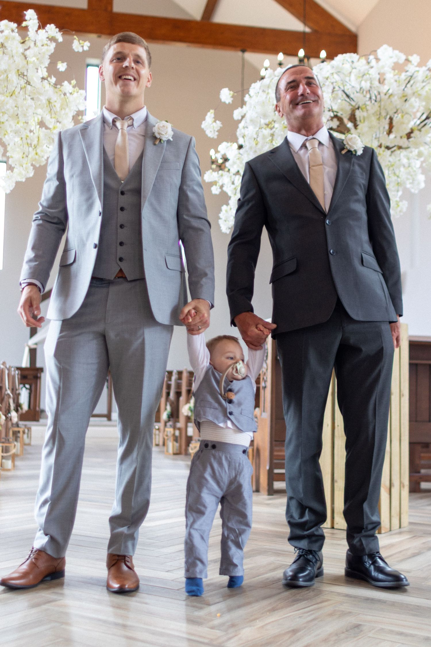 Best Man and Groom holding their son after their Wedding