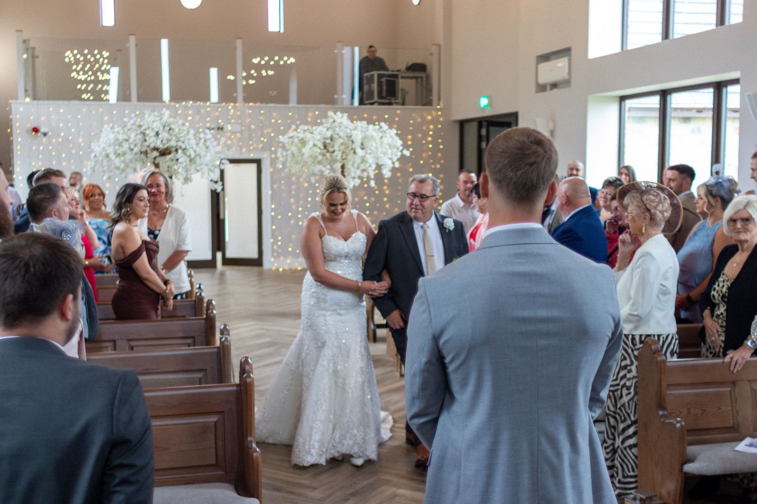 Groom watching Stepfather walk Bride down the isle at a Wedding
