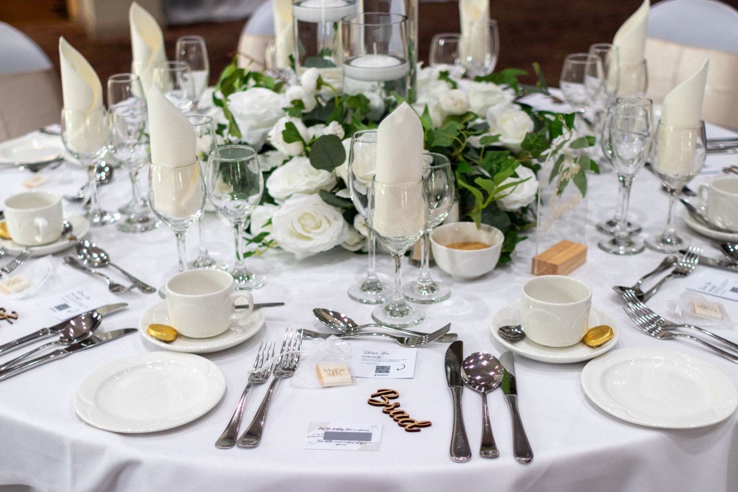 White Wedding table dressed with cutlery and wooden place markers